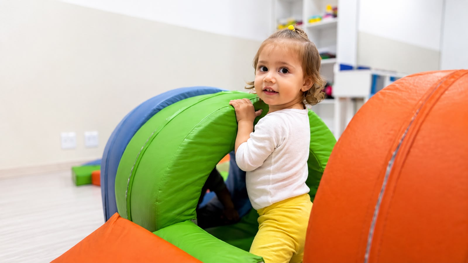 Bebê brincando no túnel do berçário da Kidsheaven, em Santana